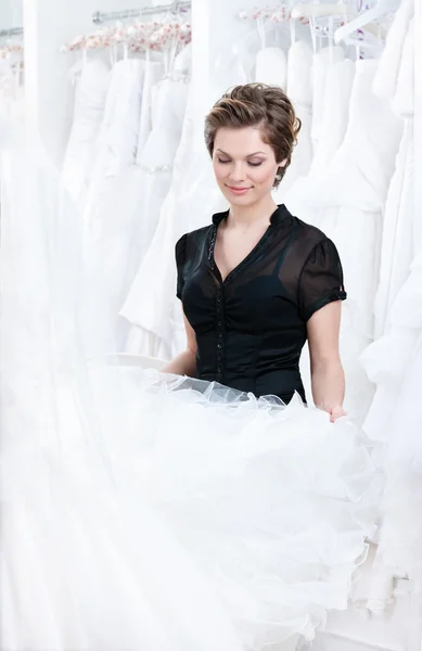 Assistente de loja quer selecionar um vestido adequado para o cliente — Fotografia de Stock