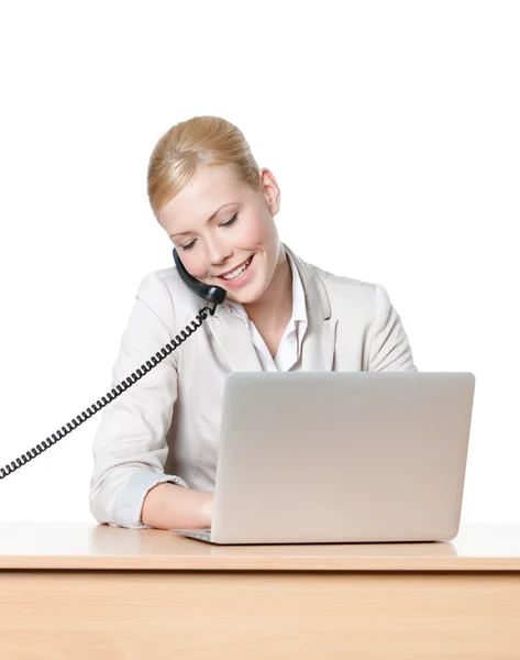 Young businesswoman sitting at a table and talking by phone — Stock Photo, Image