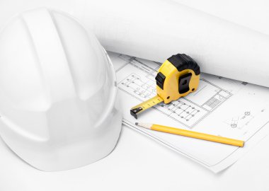 White hard hat, tape measure and pencil on the druft, isolated on white clipart