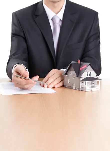 Бизнесмен подписывает договор за домовой архитектурной моделью — стоковое фото