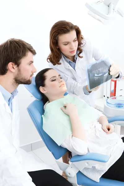 Dentist and his assistant explain details of the x ray image to the patient — Stock Photo, Image