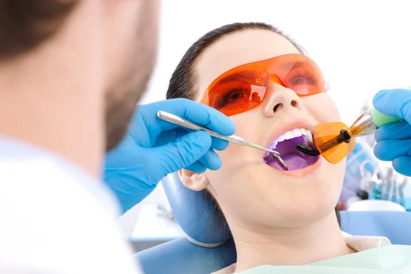 Dentysta używa fotopolimerowych Lampa leczyć zęby — Zdjęcie stockowe