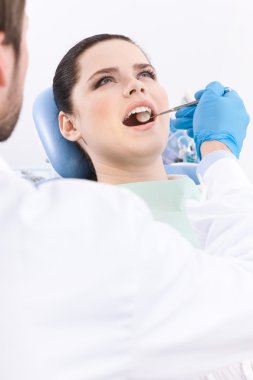 Dentist meticulously examines the oral cavity of the patient clipart
