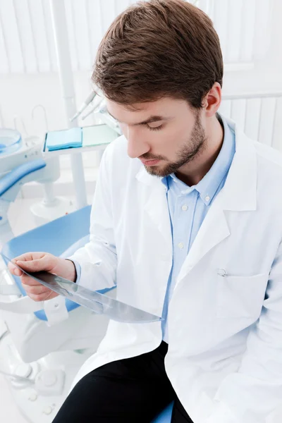 Dentista examina profundamente o roentgenograma — Fotografia de Stock