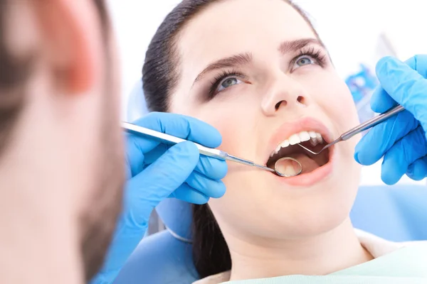 Dentist examines the teeth of the patient — Stock Photo, Image