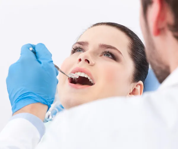 Стоматолог осматривает зубы пациента — стоковое фото