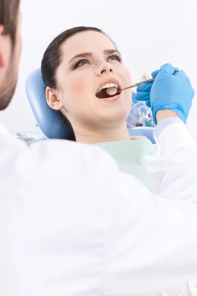 Dentista examina meticulosamente a cavidade oral do paciente — Fotografia de Stock