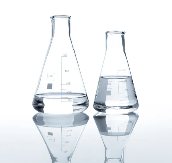 Berrak bir sıvı ile iki laboratuvar şişeler — Stok fotoğraf