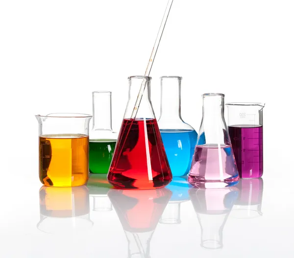 Diverse laboratoriekolber med fargede liqiuds stockfoto