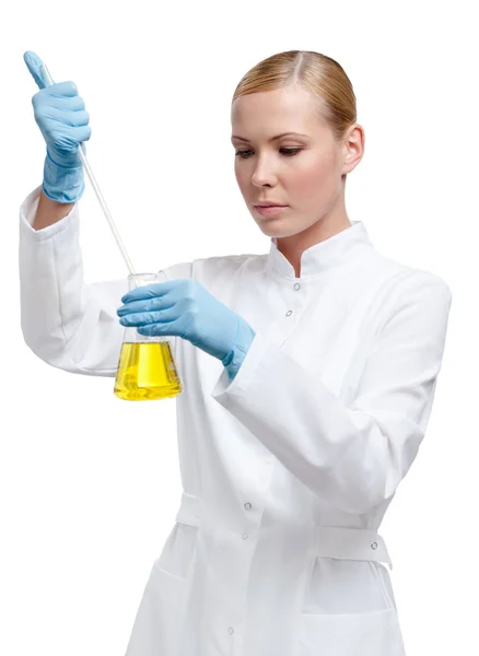 Chemik nalévá něco žlutá tekutina v baňce — Stock fotografie
