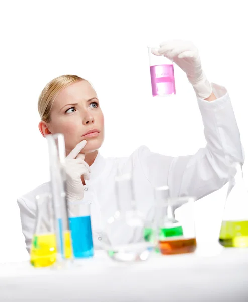 Young lady scientist stares at the beaker — Stock Photo, Image