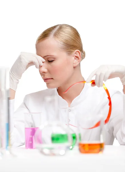 Cansado médico femenino está rodeado de cristalería médica — Foto de Stock