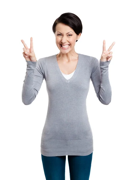 Mujer sonriente muestra signo de victoria con dos manos —  Fotos de Stock