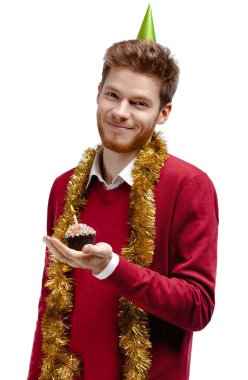 Smiley man with tinsel holds small cake clipart