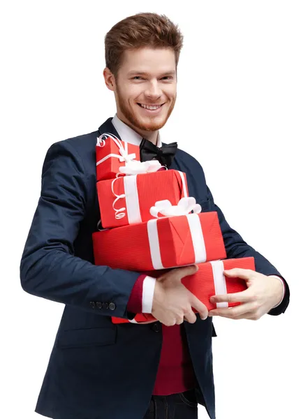 Glücklicher junger Mann trägt viele Geschenke bei sich — Stockfoto