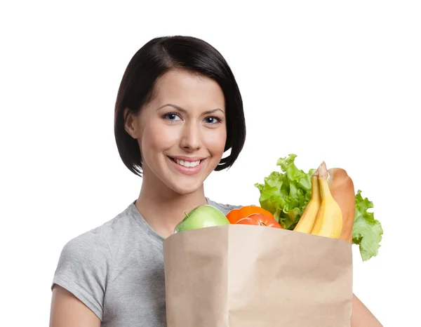 Chica sonriente mantiene el paquete de verduras — Foto de Stock