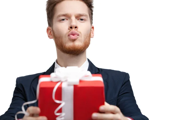 Man in strikje biedt een cadeautje en blaast een kus — Stockfoto