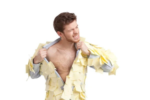 A young man ripping off his shirt, covered with stickers