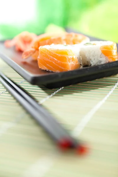 Πλάκα με σούσι και chopsticks, απομονωμένα σε λευκό — Φωτογραφία Αρχείου