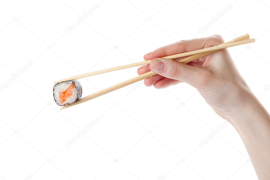 Hand holds the sushi with chopsticks