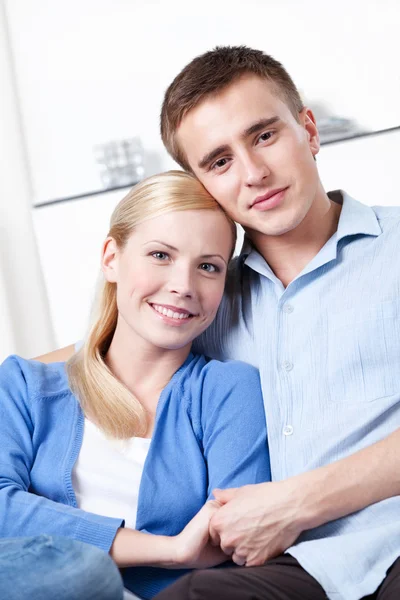 Happy couple embraces each other on the sofa — Stock Photo, Image