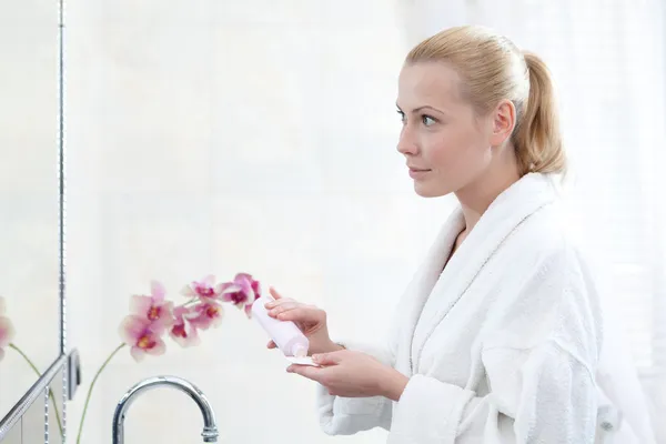 Güzel kadın losyon ile yüzünü yıkar — Stok fotoğraf