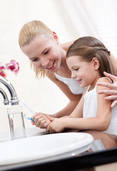 Menina limpa os dentes com a mãe — Fotografia de Stock