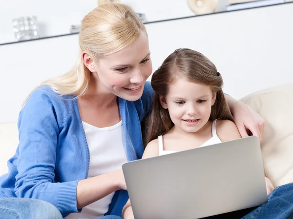 Little child surfs on the internet with her mother — Stock Photo, Image