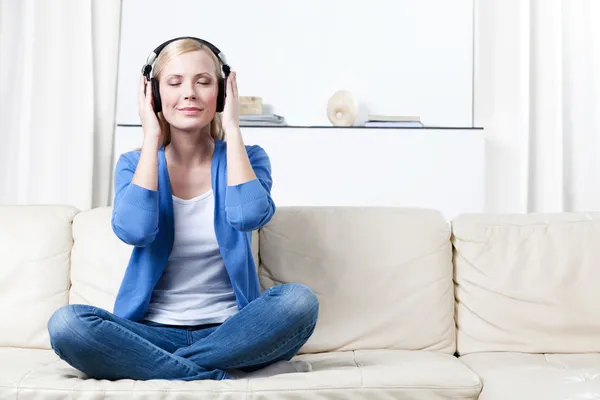 Woman in headphones listens to music — Stock Photo, Image