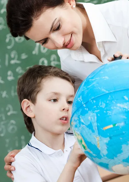 Little schoolboy uses terrestrial globe — Stock Photo, Image