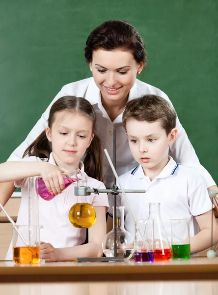 Little pupils pour chemical liquids in different flasks — Stock Photo, Image
