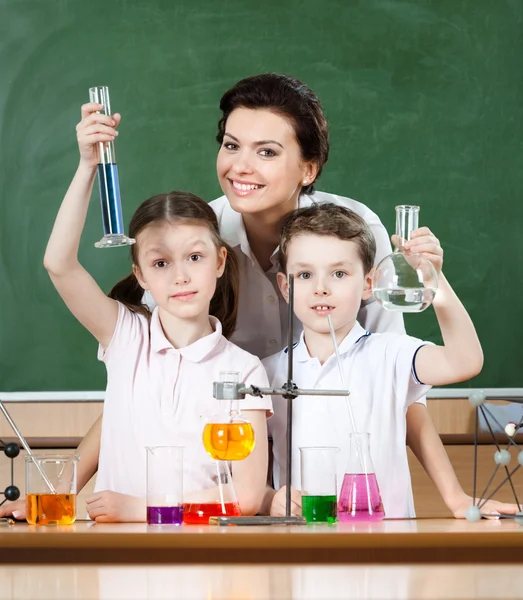 Маленькие ученики изучают химию со своим учителем — стоковое фото