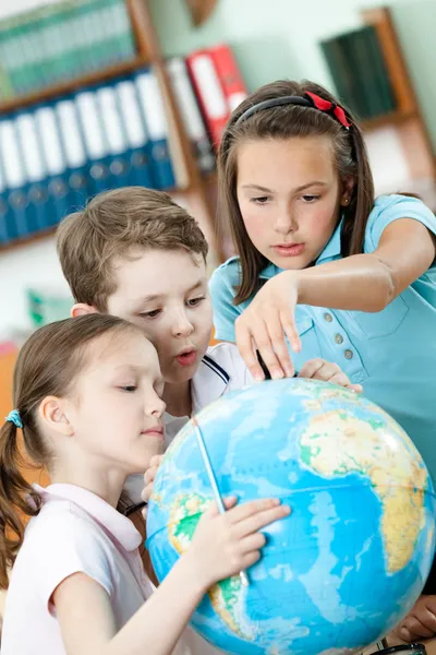 stock image Classmates help to each other to find something at the globe