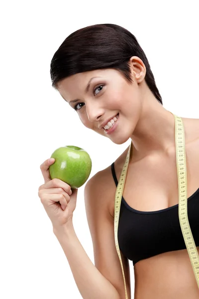 Verwöhnende Fitness-Frau mit flexiblem Lineal und grünem Apfel — Stockfoto