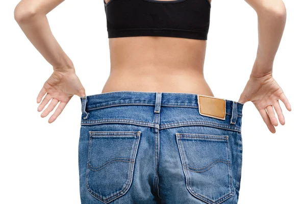 Body of a slim girl wearing enormous jeans — Stock Photo, Image