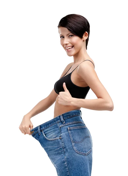 Slender woman wearing enormous jeans — Stock Photo, Image