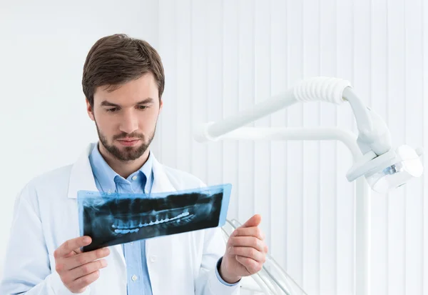 Дантист проверяет рентгенограмму — стоковое фото