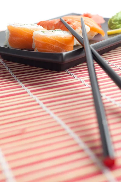 Plate with sushi and chopsticks, isolated — Stock Photo, Image