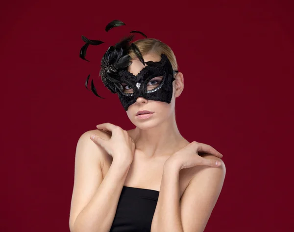 Привлекательная женщина в черной маскарадной маске с перьями — стоковое фото