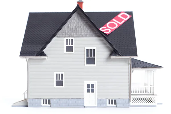 Модель дома с вывеской "Продано", изолированная — стоковое фото