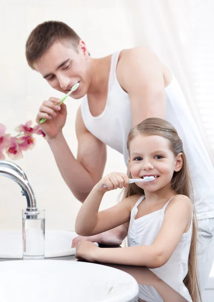 Kleines Mädchen putzt Zähne mit ihrem Vater — Stockfoto