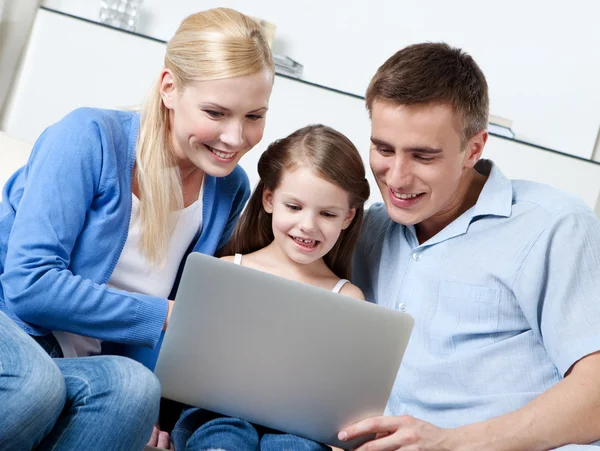 stock image Happy family sit on the sofa with laptop