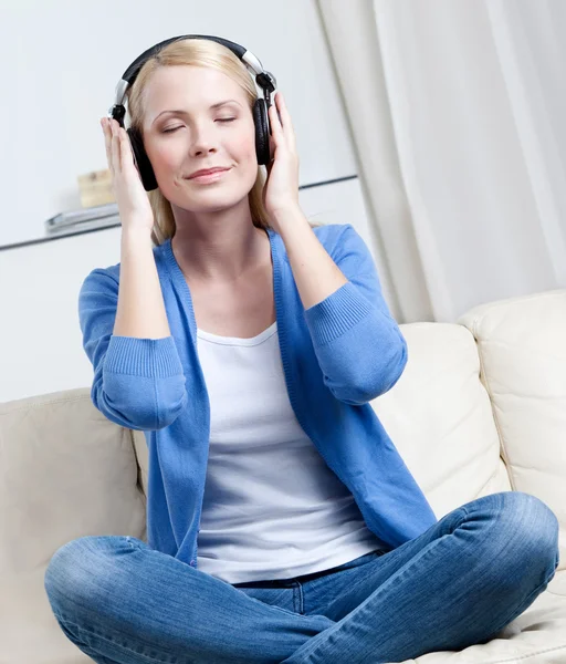 Atrakcyjna kobieta w słuchawkach słucha muzyki — Zdjęcie stockowe