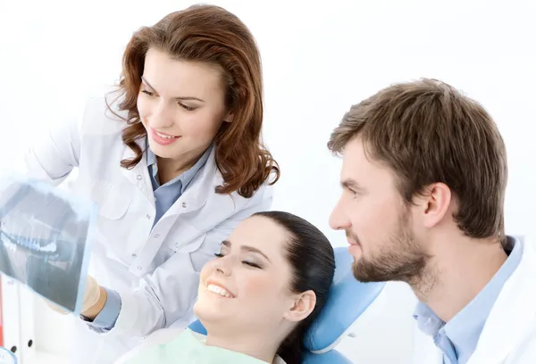 A paciente examina a foto de raios-X dos dentes. — Fotografia de Stock