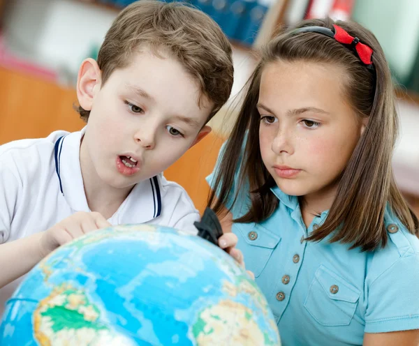 Два ученика смотрят на земной шар — стоковое фото