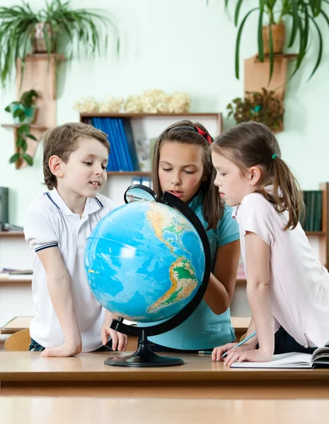 Vrienden staren op school globe — Stockfoto
