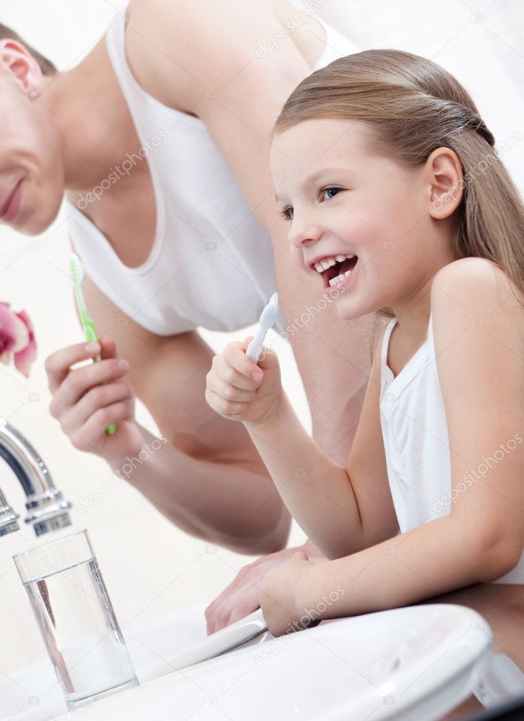 Little girl brushes teeth with her father