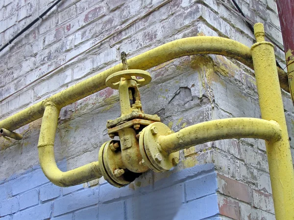 Yellow vintage gas pipe on old wall, power details. — Stock Photo, Image