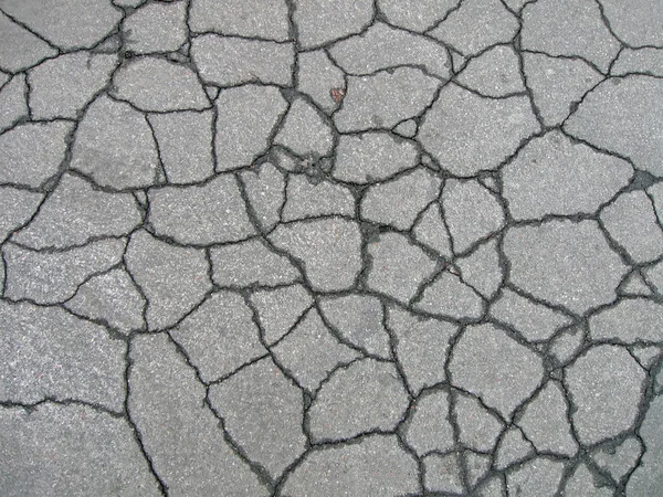 Streszczenie uszkodzonego asfaltu drogowego, kwiatek. — Zdjęcie stockowe