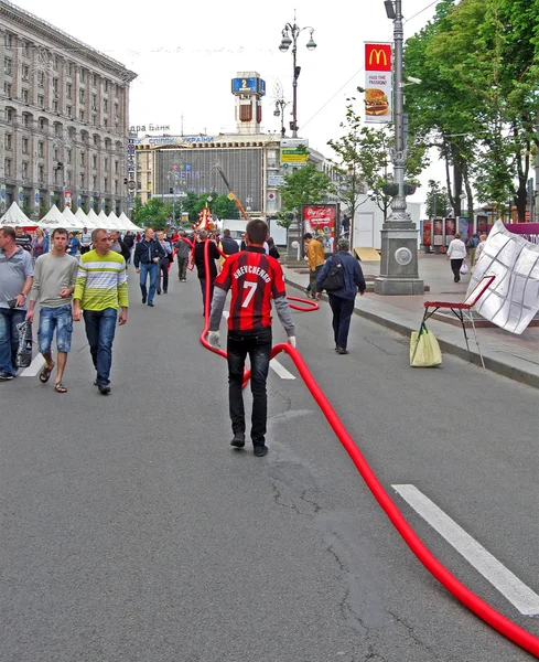 Les travailleurs portent le long câble rouge à Kiev avant EURO 2012 . — Photo